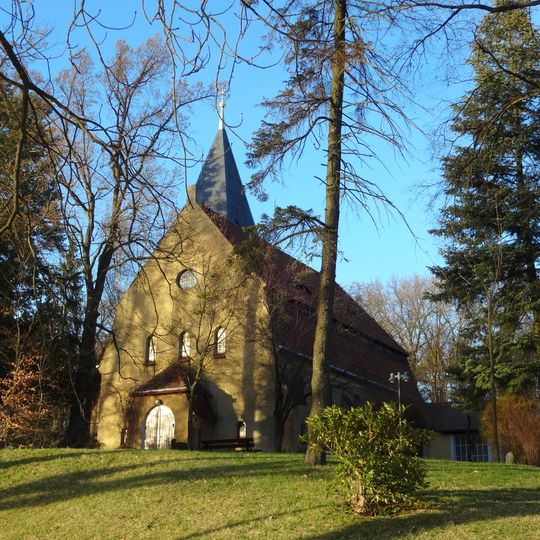 Kirche mit angebautem Pfarrhaus und Einfriedung, Denkmal für die Gefallenen des Ersten Weltkrieges sowie vier Grabanlagen und ein Grabmal auf benachbartem Friedhof Kirchweg 2