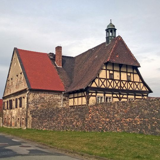 Herrenhaus mit Anbau, westliches und östliches Wirtschaftsgebäude, der östliche Teil einer Scheune sowie die Reste der Einfriedungsmauer des einstigen Rittergutes Nikrisch Thomas-Müntzer-Straße 10