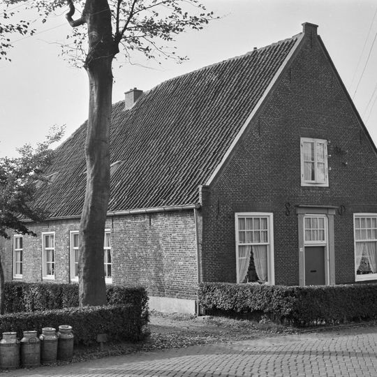 Pand met topgevel met ankers, deels ouder muurwerk aanwezig