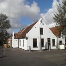 Pandje onder zadeldak tussen puntgevels met gepleisterde voorgevel met toppilaster