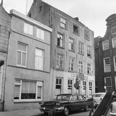 Pand met drie verdiepingen onder met pannen gedekt zadeldak (dwarskap) tussen puntgevels