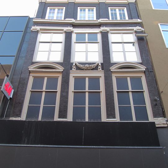 Pand met pilastergevel waarvan de top in recente lijst is afgeknot tot attiekverdieping. Vensterfrontons en festoen