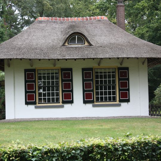 Den Treek: Tuinmanswoning met overstekend dak, rustend op houten zuilen