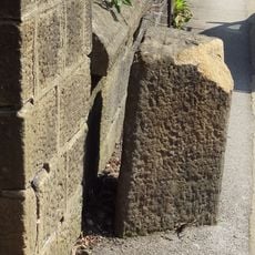 Gritstone pillar with three cup marks in the north pavement of the A65 at Horsforth, 440m south east of the roundabout at Low Fold