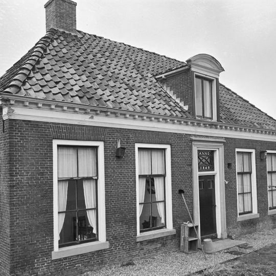 Vijf traveeën breed laag pand met omlijste ingang met bovenlicht onder schilddak met segmentvormig bekroonde dakkapel