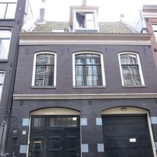 Voormalig koetshuis met gevel onder rechte lijst waarboven een dwars dak