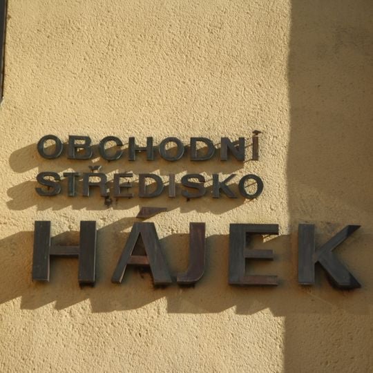 Měděný nápis Obchodní středisko Hájek na budově obchodního střediska Hájek