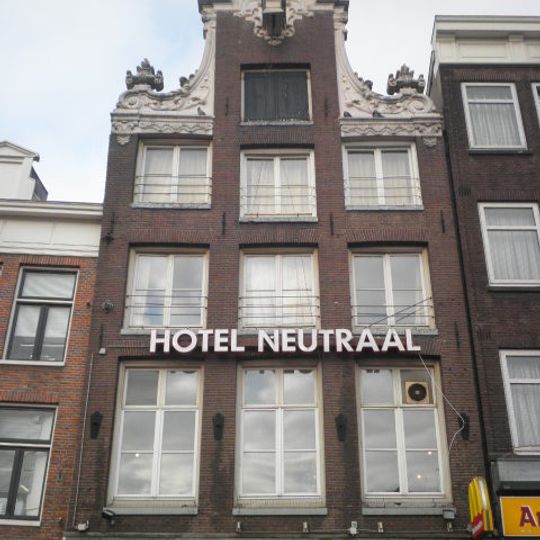 Pand met forse halsgevel met rijke top: vazen op de krullen en borstbeeld op de gelobde volutenafdekking, ornament op de hijsbalk