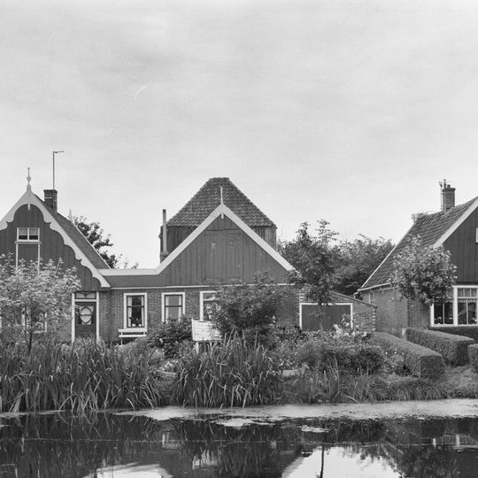 Fraai pand onder zadeldak. Houten geveltopbeschietingen, aan de voorzijde met gesneden windveren.