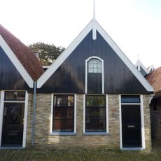 Eenvoudig pand met houten voorschot, is eigenlijk geen zelfstandig adres, maar een gedeelte van nummer 20