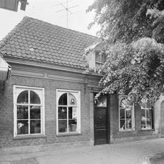 Pand zonder verdieping en onder met pannen gedekt schilddak, waarin een dakkapel met fronton