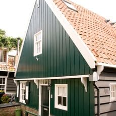 Houten huis met topgevel en daklijsten op consoles