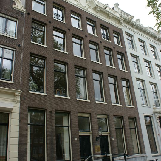 Huis achter gezamenlijke gevel met het nr 219 onder verhoogde lijst met consoles empire deur