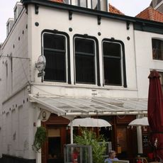 Huis met tweede helft 19e eeuw gepleisterde rechte gevel. Gootlijst op consoles. Dakkapel. Moderne winkelpui