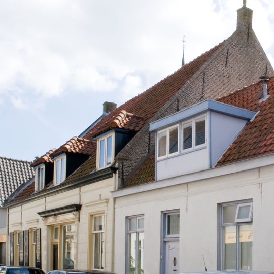 Eenvoudig dorpshuis met dwars zadeldak en zijtopgevels met vlechtingen