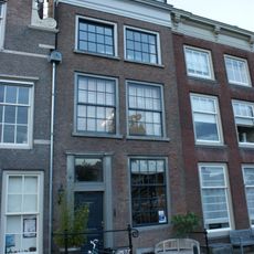 Pand met lijstgevel met deur met pilasteromlijsting en bovenlicht