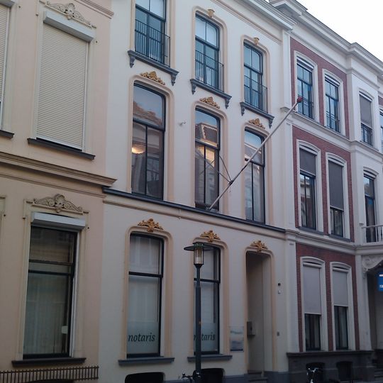 Pand dat onderdeel vormt van een in het derde kwart van de 19e eeuw als een symmetrisch geheel ontworpen straatwand