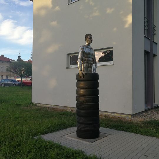 Kovová socha muže v pneumatikách