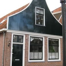 Huis met houten topgevel. Oorspronkelijk kozijnen