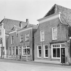 Pand met hoog wolfdak en gepleisterde voorgevel met ingezwenkte zijkanten en houten kroonlijst