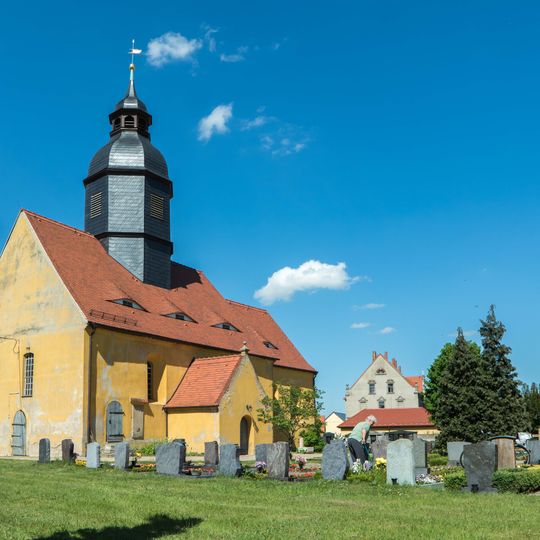 Kirche , Kirchhof mit Einfriedung, Kriegerdenkmal für die Gefallenen des 1. Weltkrieges sowie Epitaph in der Kirchenwand und drei Grabmale an der Kirchhofsmauer Baudaer Straße 4a