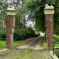 Bakstenen boogbrug en met leeuwen bekroonde bakstenen hekpijlers
