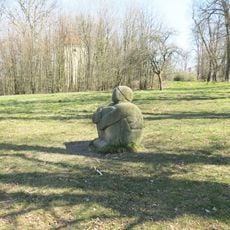 Socha sedící postavy na louce u aleje k zámku Lemberk