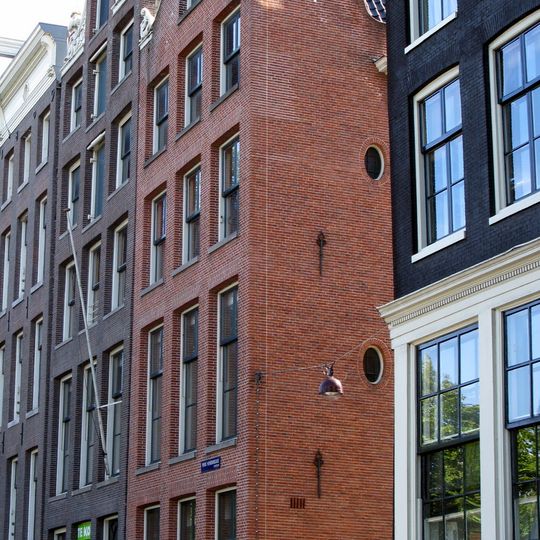 Pand bestaande uit een nieuw opgetrokken rechterhelft, waarop de oude ingezwenkte hals van het vroegere nr 138 en een linkerhelft met halsgevel