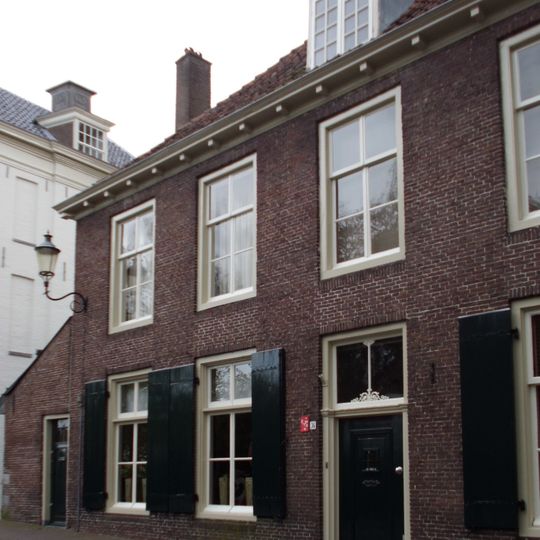 Pand, deel uitmakend van rij aaneengeschakelde 19e-eeuwse huizen, in bocht van de singel gelegen onder een rechte daklijst. Harmonische raamverdeling met luiken