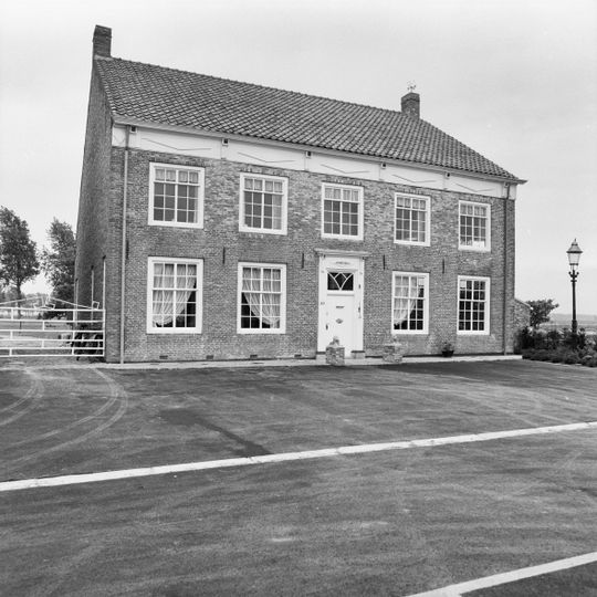 Gedeeltelijk onderkelderd pand, aan de wegzijde met een verdieping