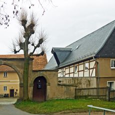 Wohnstallhaus eines Bauernhofes und Hofmauer mit Torbogen und Pforte Basteistraße 60