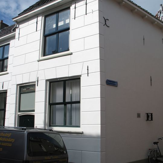 Pand met muurankers en gepleisterde rechte gevel met linkerdeel onder dwars schilddak