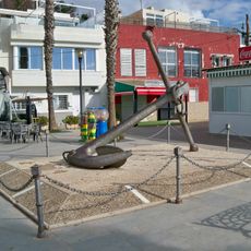 Una antigua ancla de grandes dimensiones a modo de escultura pública.