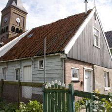 Houten huis met topgevel en daklijst op consoles