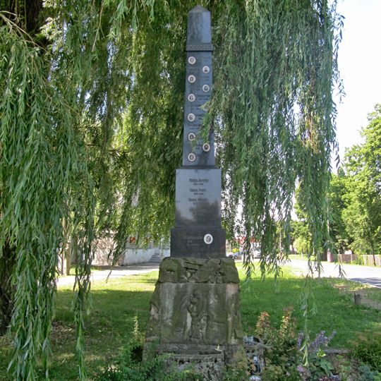 Pomník padlým v obou světových válkách u hlavní komunikace ve středu Vlkoše