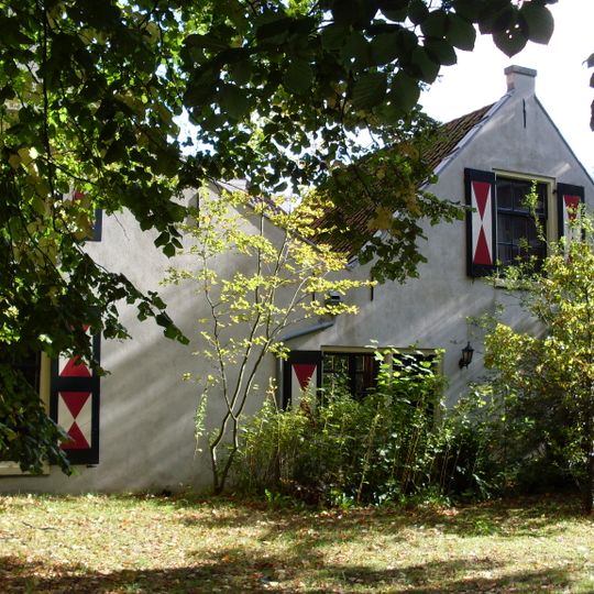 Lage landelijke gepleisterde woning met dubbele topgevel, kleine roeden, blinden