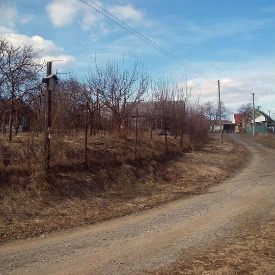 Kříž Podlenů jižně od Horní Bělé u plotu