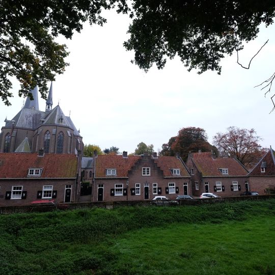 Symmetrisch opgebouwd centraal woonblok, bestaande uit drie aaneengesloten eengezinswoningen, waarvan de middenwoning eindigt in een trapgevel