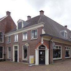 Pand met gevel met getande kroonlijst, houten deuromlijsting