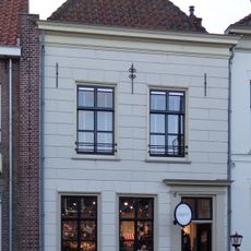 Huis met mooi schilddak en gepleisterde gevel met muurankers onder lijst