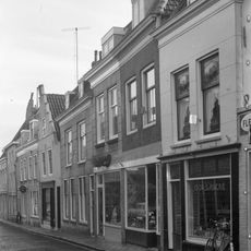 Huis met hoog zadeldak achter gepleisterde lijstgevel