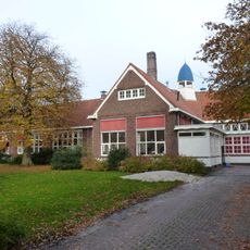 Schoolgebouw in regionale Amsterdamse Schoolstijl met Engelse landhuisstijl-elementen