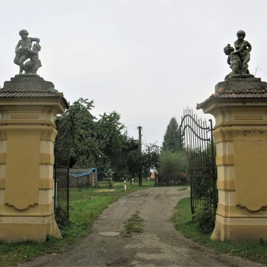 Sochy putti na sloupech brány naproti zámku ve Vidimi