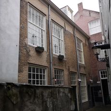 Aan de zuidzijde langs de Binnen Dieze gelegen, in gele baksteen opgetrokken pand met verdieping onder met pannen gedekt zadeldak