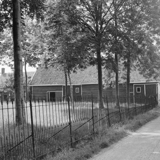 Kleine hoeve. Gepleisterd woonhuis met pannen gedekt. Voordeur in langsgevel aan de straat met bewerkt kalf. Dicht bijeen gelegen staafankers. Bakgoot op klossen. T-schuiframen met paneelluiken.