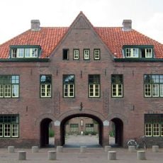 Poortgebouw met woningen in Traditionele stijl in een straatwand