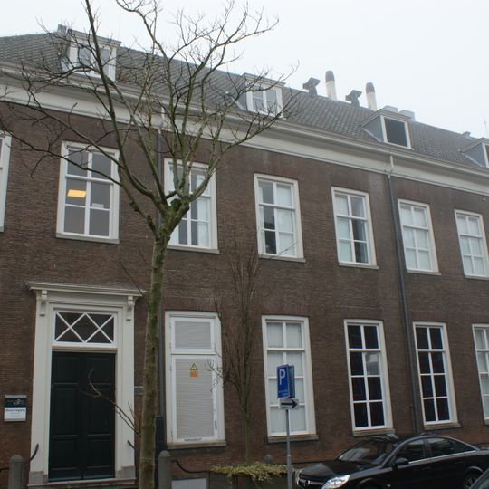 Achterzijde van het Museum van Oudheden "Hof van Zessen". Lange bakstenen gevels met rechte kroonlijst. Hardstenen stoep met palen, waaronder oude stallen