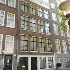 Twee smalle woningen achter gemeenschappelijke lijstgevel met geblokte pui