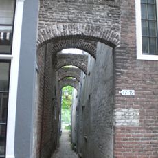 Huis met in- en uitgezwenkte topgevel met vijf door geprofileerde natuurstenen platen gedekte pinakels