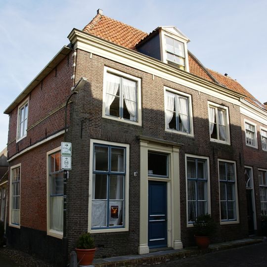 Pand met eenvoudige laat 18e-eeuwse gevel met rechte kroonlijst en dwarskap. Zijgevel aan de Dijkstraat en achterhuis